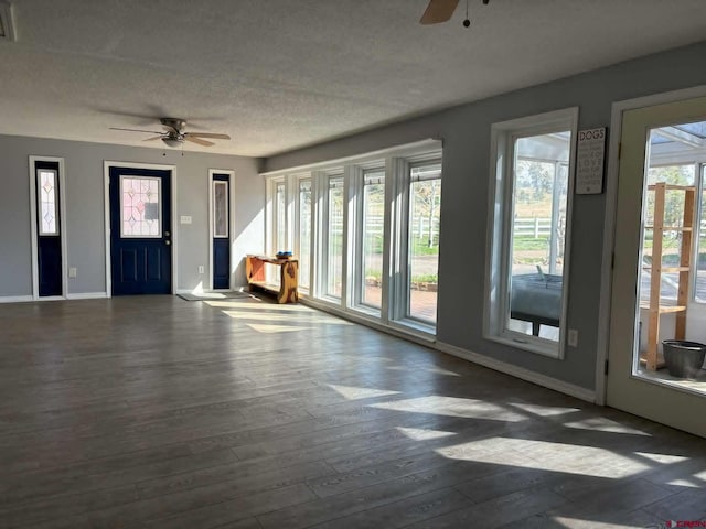 541 Perry Dr, Pagosa Springs, CO 81147 - unfurnished living room with a ceiling fan, baseboards, hardwood / wood-style flooring, and a textured ceiling