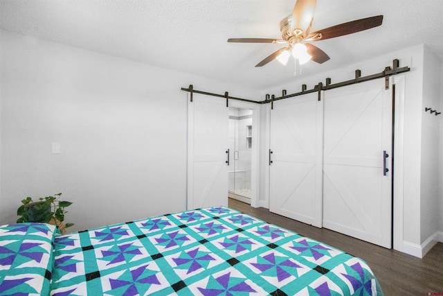 541 Perry Dr, Pagosa Springs, CO 81147 - bedroom featuring a barn door, wood finished floors, a textured ceiling, baseboards, and a ceiling fan