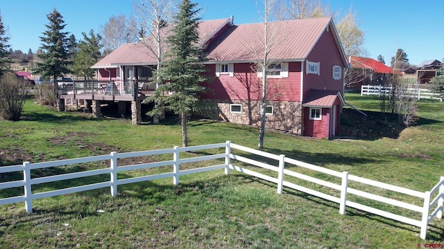541 Perry Dr, Pagosa Springs, CO 81147 - back of house featuring stone siding, a wooden deck, an outdoor structure, and metal roof