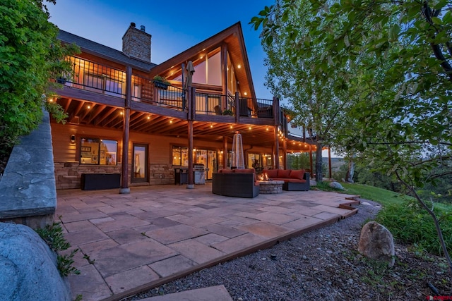 50 W Durango Ridge Rd, Durango, CO 81301 - back of property featuring an outdoor living space with a fire pit, a patio, a chimney, stone siding, and a deck