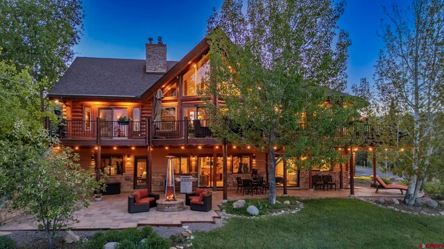 50 W Durango Ridge Rd, Durango, CO 81301 - back of house featuring a patio, a chimney, log siding, a yard, and an outdoor living space with a fire pit