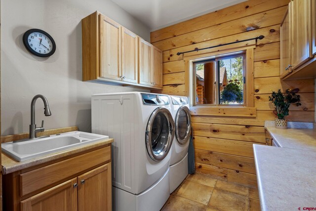 50 W Durango Ridge Rd, Durango, CO 81301 - washroom featuring separate washer and dryer, wooden walls, cabinet space, and light stone finish flooring