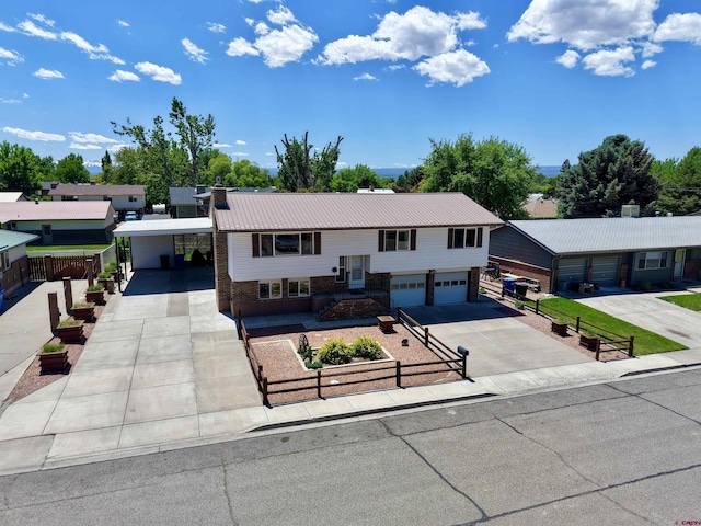 2020 Essex St, Montrose, CO 81401 - raised ranch featuring concrete driveway, brick siding, an attached carport, and metal roof