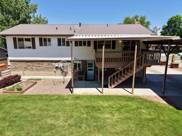 2020 Essex St, Montrose, CO 81401 - rear view of house with a patio area, a lawn, brick siding, and metal roof