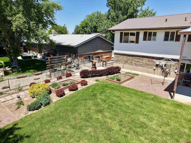 2020 Essex St, Montrose, CO 81401 - rear view of house featuring a vegetable garden, a lawn, a patio area, and brick siding