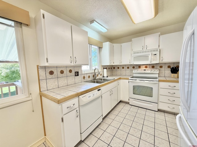 2020 Essex St, Montrose, CO 81401 - kitchen featuring white appliances, a sink, tile counters, decorative backsplash, and a textured ceiling