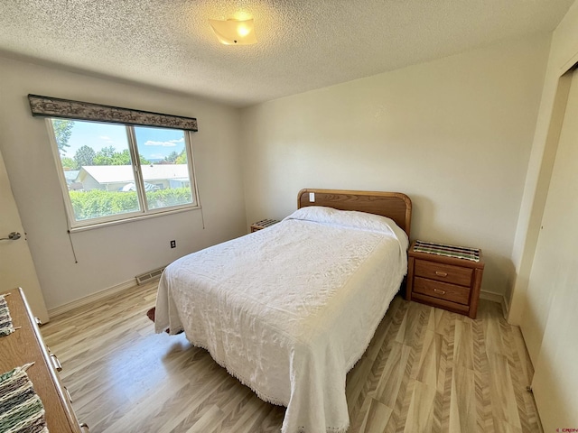 2020 Essex St, Montrose, CO 81401 - bedroom featuring light wood-style floors, a textured ceiling, and baseboards