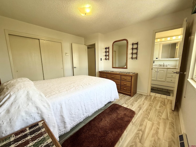 2020 Essex St, Montrose, CO 81401 - bedroom featuring light wood-style flooring, a closet, a textured ceiling, a sink, and ensuite bath
