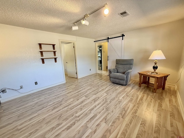 2020 Essex St, Montrose, CO 81401 - sitting room featuring a barn door, light wood-style floors, a textured ceiling, and baseboards