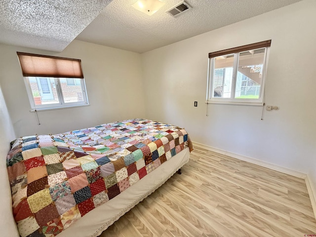 2020 Essex St, Montrose, CO 81401 - bedroom with light wood-style floors, a textured ceiling, and baseboards