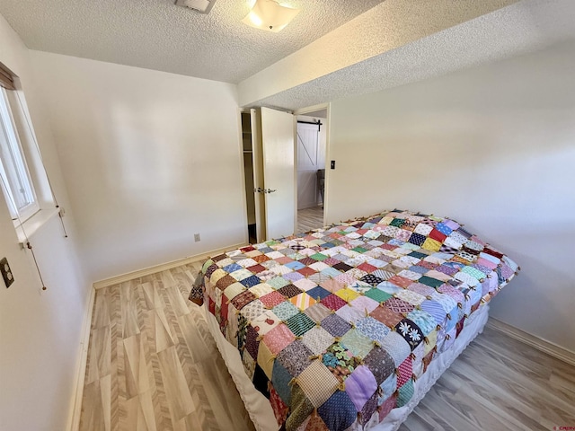 2020 Essex St, Montrose, CO 81401 - bedroom featuring wood finished floors, a textured ceiling, and baseboards