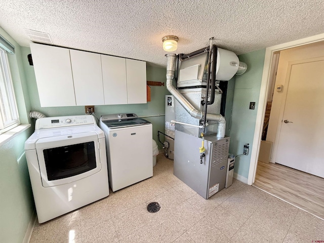 2020 Essex St, Montrose, CO 81401 - laundry room featuring washer and dryer, cabinet space, baseboards, a textured ceiling, and gas water heater