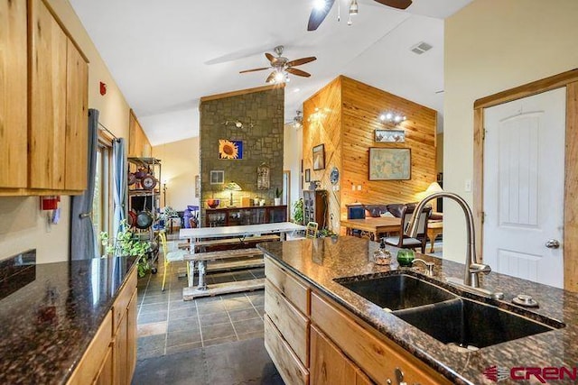 538 Rugby Mines Rd, Walsenburg, CO 81089 - kitchen with a sink, ceiling fan, lofted ceiling, wooden walls, and dark stone counters