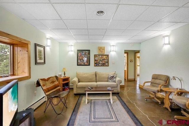 538 Rugby Mines Rd, Walsenburg, CO 81089 - living room with finished concrete floors, a paneled ceiling, a baseboard radiator, and baseboards