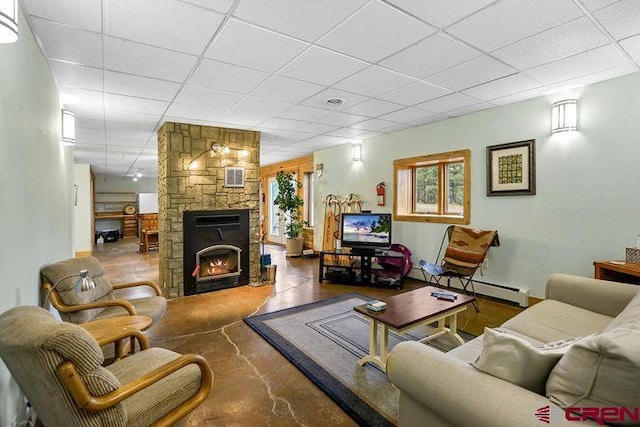 538 Rugby Mines Rd, Walsenburg, CO 81089 - living room with a drop ceiling, finished concrete flooring, a baseboard radiator, and a stone fireplace