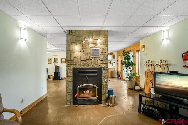 538 Rugby Mines Rd, Walsenburg, CO 81089 - living area with concrete floors, baseboards, a fireplace, and a drop ceiling