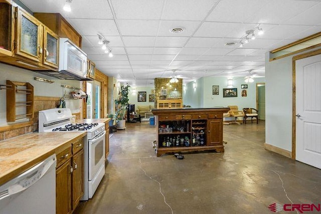 538 Rugby Mines Rd, Walsenburg, CO 81089 - kitchen featuring white appliances, ceiling fan, concrete flooring, brown cabinets, and a drop ceiling