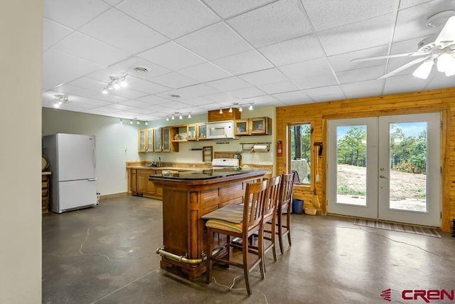 538 Rugby Mines Rd, Walsenburg, CO 81089 - indoor bar featuring white appliances, french doors, concrete floors, a drop ceiling, and track lighting
