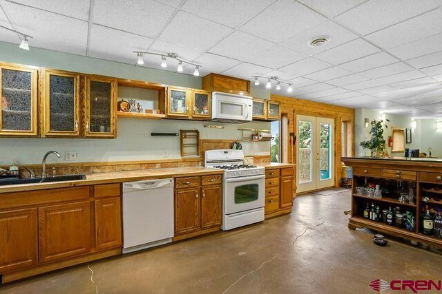 538 Rugby Mines Rd, Walsenburg, CO 81089 - kitchen featuring white appliances, brown cabinetry, open shelves, a sink, and finished concrete flooring
