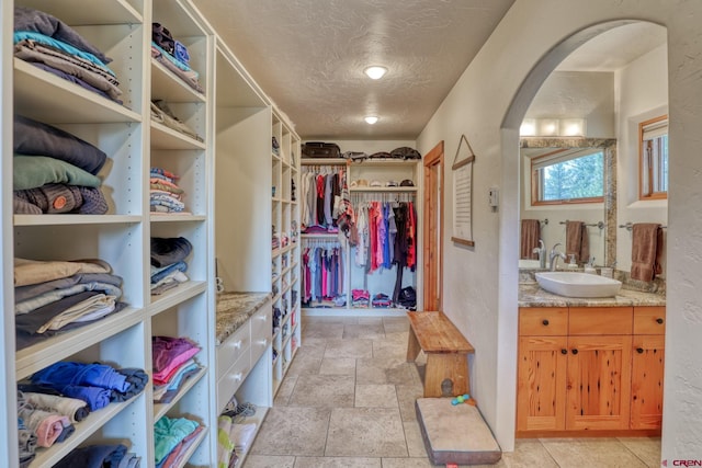 520B Whispering Wood Dr, Pagosa Springs, CO 81147 - spacious closet with a sink, arched walkways, and stone tile flooring