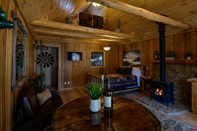 520B Whispering Wood Dr, Pagosa Springs, CO 81147 - living room featuring a wood stove, wood finished floors, wood walls, and wooden ceiling with exposed beams