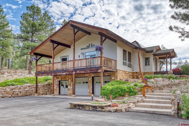 520B Whispering Wood Dr, Pagosa Springs, CO 81147 - view of front of home featuring stone siding, driveway, a garage, stairway, and stucco siding
