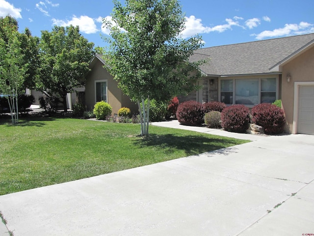 1756 Freedom Way, Montrose, CO 81401 - view of front of home featuring a front yard, stucco siding, concrete driveway, and a shingled roof