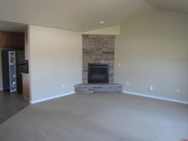1756 Freedom Way, Montrose, CO 81401 - unfurnished living room featuring vaulted ceiling, a stone fireplace, baseboards, and carpet