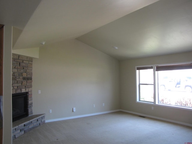 1756 Freedom Way, Montrose, CO 81401 - unfurnished living room featuring light colored carpet, lofted ceiling, a stone fireplace, and baseboards