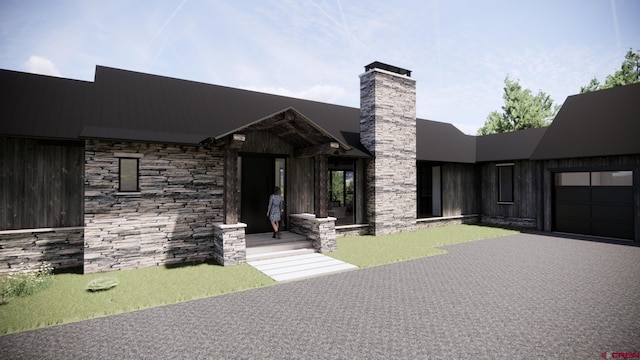 1620 Red Mountain Ranch Rd, Crested Butte, CO 81225 - view of front facade featuring an attached garage, stone siding, a chimney, and asphalt driveway