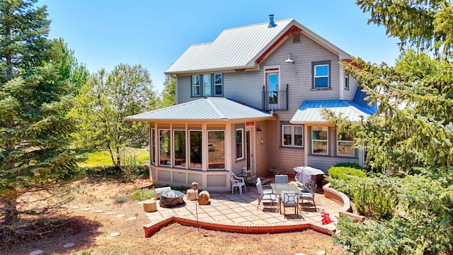 15307 Rd R, Cahone, CO 81320 - rear view of property with metal roof, a patio, a standing seam roof, and a sunroom