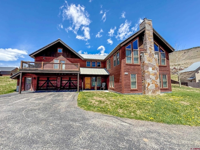 405 Meridian Lake Dr, Crested Butte, CO 81224 - view of front of house featuring an attached garage, a front lawn, driveway, a chimney, and metal roof