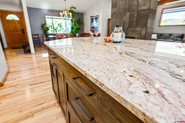 125 Ball Ln, Durango, CO 81301 - kitchen featuring light stone counters, a chandelier, light wood-style flooring, and hanging light fixtures