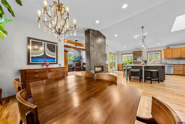 125 Ball Ln, Durango, CO 81301 - dining space with light wood-style flooring, lofted ceiling, a tiled fireplace, recessed lighting, and a chandelier