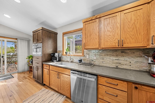 125 Ball Ln, Durango, CO 81301 - kitchen with stainless steel appliances, decorative backsplash, vaulted ceiling, light wood-style floors, and a sink