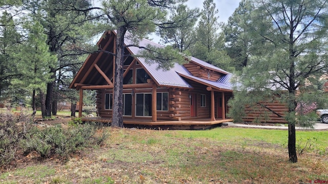 33 Fawn Ct, Pagosa Springs, CO 81147 - view of front of house with log exterior, metal roof, and covered porch