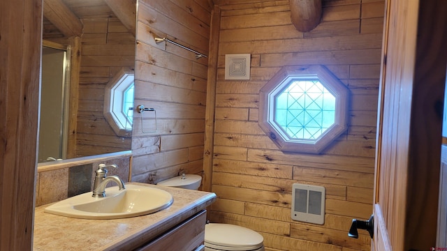 33 Fawn Ct, Pagosa Springs, CO 81147 - bathroom featuring heating unit, wood walls, toilet, vanity, and a shower with shower door