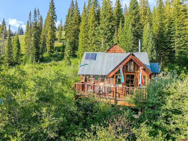 201 10th St, Crested Butte, CO 81224 - back of house featuring metal roof, a wooden deck, and a wooded view