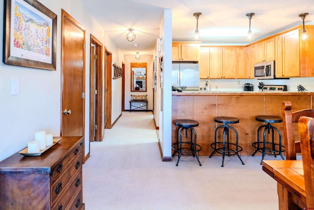 35 Emmons Rd Unit 11, Mount Crested Butte, CO 81225 - kitchen with stainless steel appliances, light carpet, and a breakfast bar area