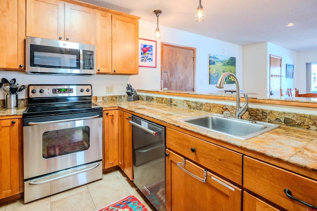 35 Emmons Rd Unit 11, Mount Crested Butte, CO 81225 - kitchen featuring appliances with stainless steel finishes, a sink, light tile patterned floors, a textured ceiling, and decorative light fixtures