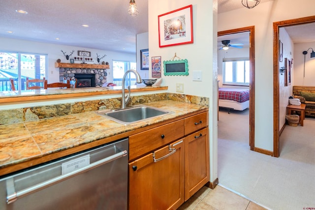 35 Emmons Rd Unit 11, Mount Crested Butte, CO 81225 - kitchen with stainless steel dishwasher, a sink, a textured ceiling, a ceiling fan, and a fireplace