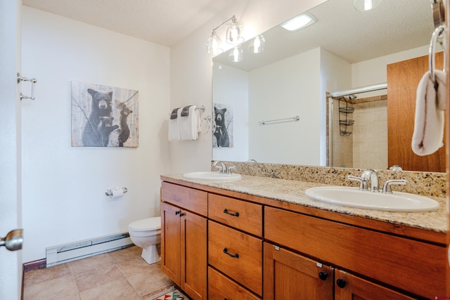 35 Emmons Rd Unit 11, Mount Crested Butte, CO 81225 - full bathroom featuring a baseboard heating unit, double vanity, toilet, tiled shower, and a textured ceiling
