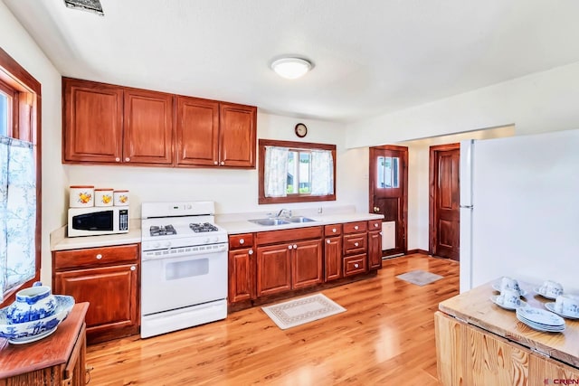 175 NW 4th St, Cedaredge, CO 81413 - kitchen featuring white appliances, a sink, light countertops, and light wood finished floors