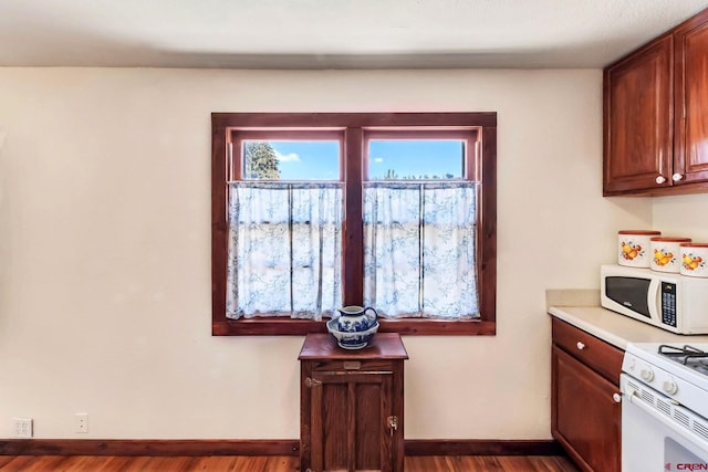 175 NW 4th St, Cedaredge, CO 81413 - kitchen with white appliances, dark wood-style flooring, baseboards, and light countertops