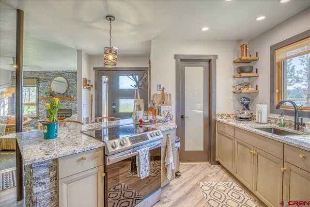 190 Luxury Pl Unit 3, Pagosa Springs, CO 81147 - kitchen with stainless steel electric range oven, a sink, open shelves, light wood finished floors, and light stone countertops