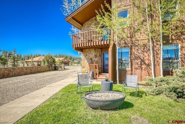 190 Luxury Pl Unit 3, Pagosa Springs, CO 81147 - back of property featuring stone siding, a yard, and a balcony