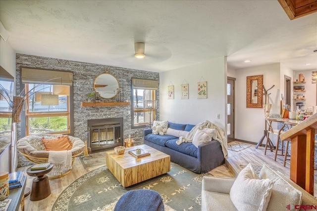 190 Luxury Pl Unit 3, Pagosa Springs, CO 81147 - living room with wood finished floors, a ceiling fan, a fireplace, baseboards, and a textured ceiling