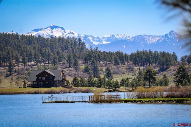 190 Luxury Pl Unit 3, Pagosa Springs, CO 81147 - water view with a floating dock, a mountain backdrop, and a heavily wooded area