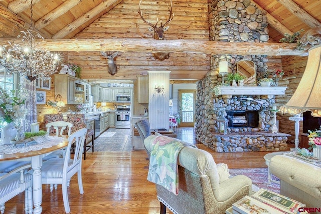 598 Blue Jay Cir, Pagosa Springs, CO 81147 - living area featuring wooden ceiling with exposed beams, light wood-style floors, rustic walls, high vaulted ceiling, and a chandelier