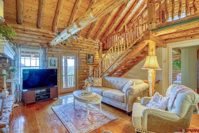 598 Blue Jay Cir, Pagosa Springs, CO 81147 - living room with wood ceiling with exposed beams, rustic walls, hardwood / wood-style flooring, high vaulted ceiling, and stairs